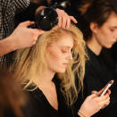 A model gets her hair styled backstage at the John Rocha show © Getty