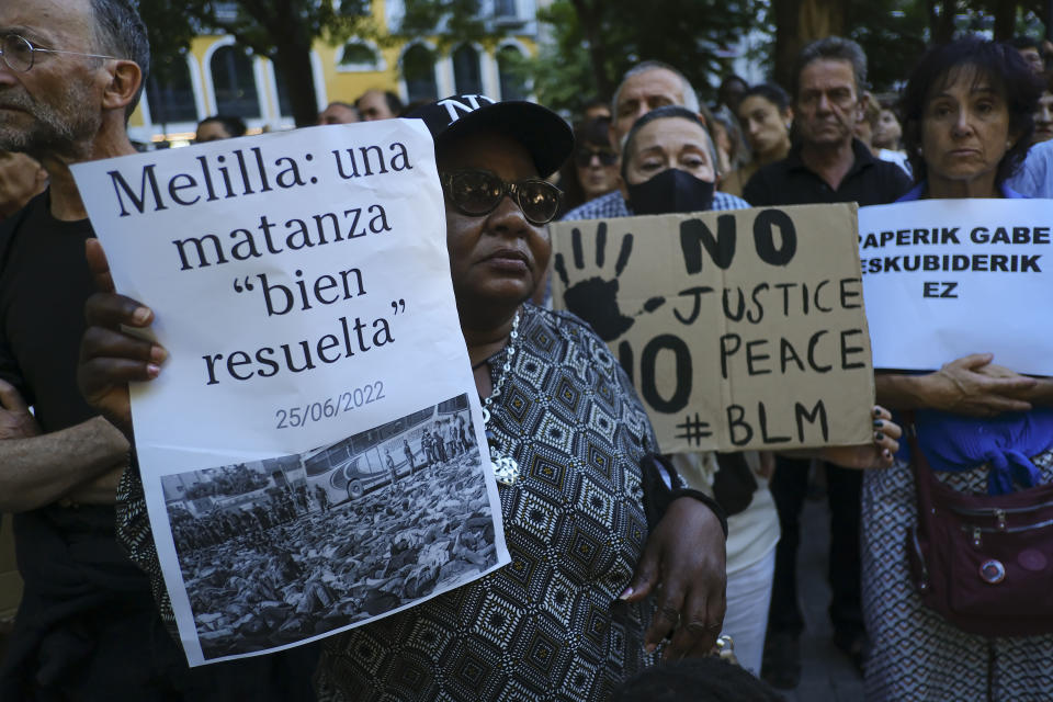 A woman holds up a banner that reads: "Melilla, a well-resolved massacre", during one of many protests across Spain amid for the investigation over the deaths of at least 23 people at the border between the Spanish enclave of Melilla and Morocco, in Pamplona, northern Spain, Friday, July 1, 2022. (AP Photo/Alvaro Barrientos)
