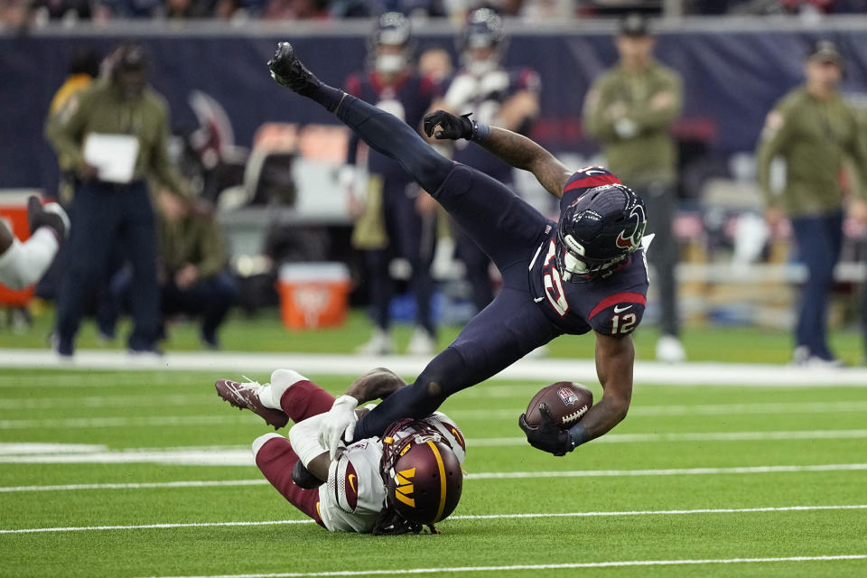 Houston Texans wide receiver Nico Collins (12) is stopped by Washington Commanders safety Bobby McCain (20) after a catch during the second half of an NFL football game Sunday, Nov. 20, 2022, in Houston. (AP Photo/David J. Phillip)