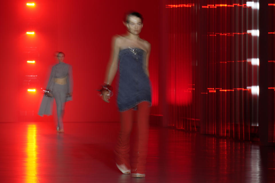 In this image taken with a slow shutter speed, a model wears a creation as part of the Jordanluca men's and women's Spring Summer 2024 collection, unveiled during the Fashion Week in Milan, Italy, Saturday, June 17, 2023. (AP Photo/Antonio Calanni)