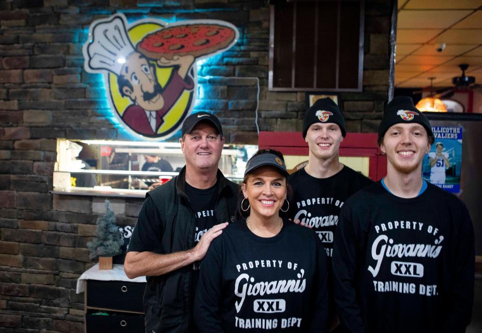 Mike and Leslie Payne and sons Cameron Logan Snowden stand inside Giovanni's Pizza on November 15, 2022 in Chillicothe, Ohio.