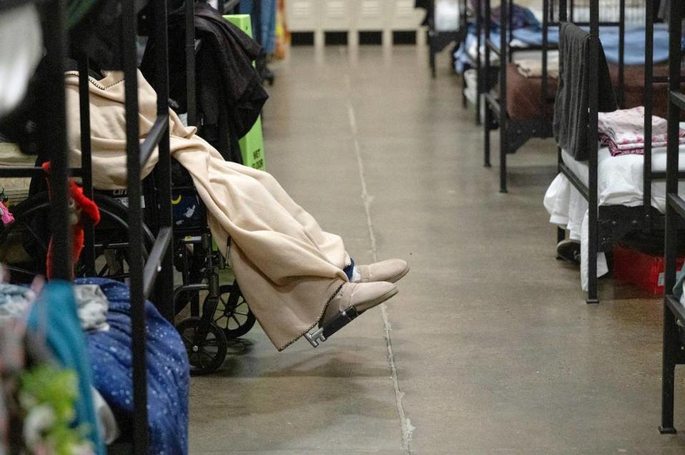 An elderly woman sits in a wheelchair at the county’s low-barrier shelter at the Salvation Army Berberian Center in Modesto, Calif., Wednesday, Nov. 22, 2023.