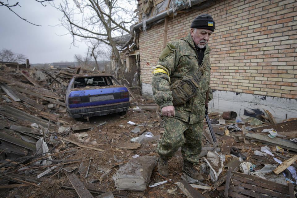 Andrey Goncharuk, 68, a member of territorial defense, walks in the backyard of a house damaged by a Russian airstrike, according to locals, in Gorenka, outside the capital Kyiv, Ukraine, Wednesday, March 2, 2022. Russia renewed its assault on Ukraine's second-largest city in a pounding that lit up the skyline with balls of fire over populated areas, even as both sides said they were ready to resume talks aimed at stopping the new devastating war in Europe.(AP Photo/Vadim Ghirda)