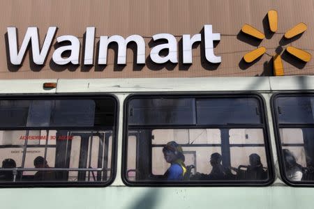 A clown sits inside a bus seen in front of a Wal-Mart store in Mexico City January 11, 2013. REUTERS/Edgard Garrido/File Photo