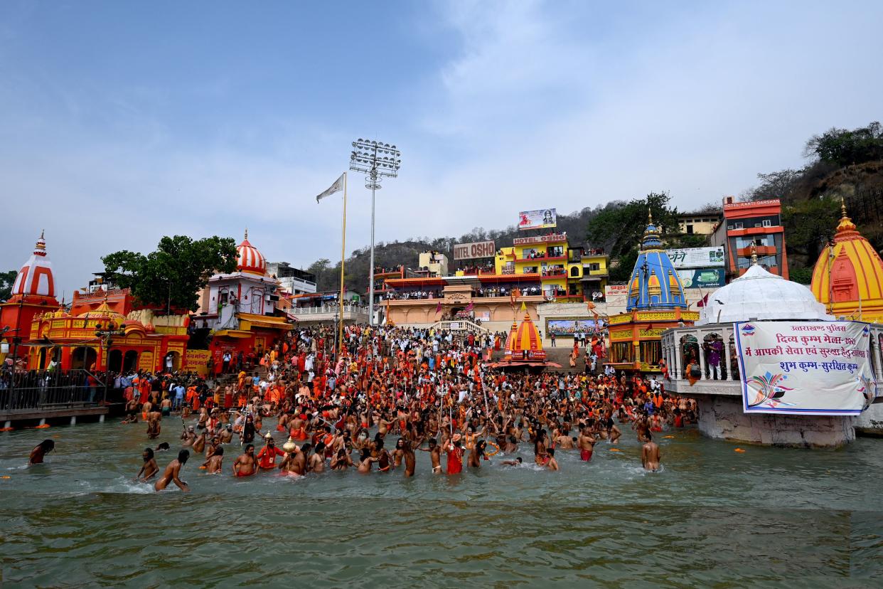 Naga Sadhus (Hindu holy men) take a holy dip in the waters of the Ganges River on the day of Shahi Snan (royal bath) during the ongoing religious Kumbh Mela festival, in Haridwar on April 12, 2021. (Photo by Money SHARMA / AFP) (Photo by MONEY SHARMA/AFP via Getty Images)