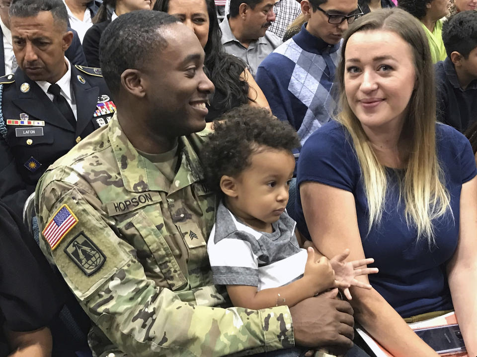 FILE - In this Sept. 20, 2017, file photo, U.S. Army Sergeant Kendrick Hopson, with son, Jaylen, 2, accompany his wife, Patricia Hopson, originally from Germany, as she joins other immigrants taking the citizenship oath during naturalization ceremonies at a U.S. Citizenship and Immigration Services (USCIS) ceremony in Los Angeles. A growing number of Americans say immigration should remain the same or be increased since the Trump administration ramped up immigration enforcement. That's according to the General Social Survey, which has also found a growing partisan divide on the topic. The poll shows 34 percent of Americans want immigration to be reduced, down from 41 percent in 2016. It's the first time since the question was asked in 2004 that more Americans want immigration levels to stay the same than to be reduced. (AP Photo/Damian Dovarganes, File)