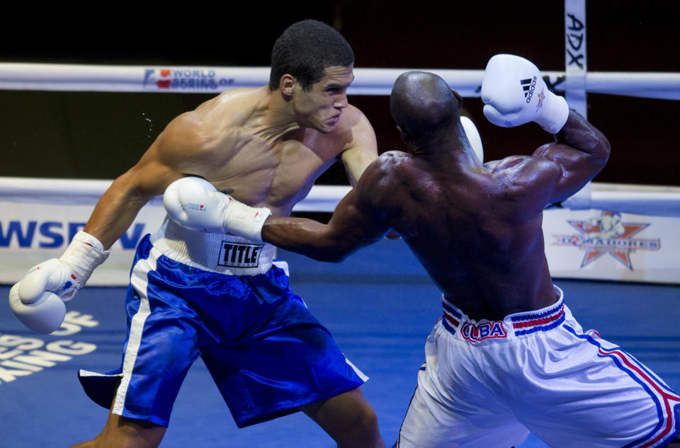 Cuban boxer Emilio Correa, right, fights with Michel Borges de Souza of the U.S. during their men's 81kg boxing match in Havana, Cuba, Friday, April. 4, 2014. Boxers from the U.S. and Cuba went glove-to-glove on Cuban soil for the first time in 27 years Friday in a semipro World Series of Boxing clash (AP Photo/Ramon Espinosa)