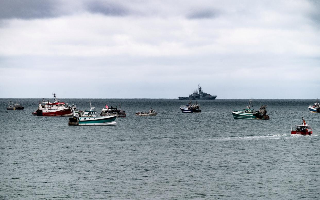 A British gunboat keeps an eye on the flotilla of fishing vessels seen outside St Helier harbour, Jersey, as French fishermen protest post-Brexit changes to fishing in the area - saltylens_ci / matt noel / SWNS