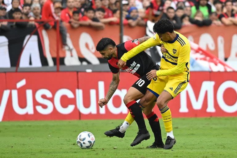 Banega cubre la pelota ante Medina