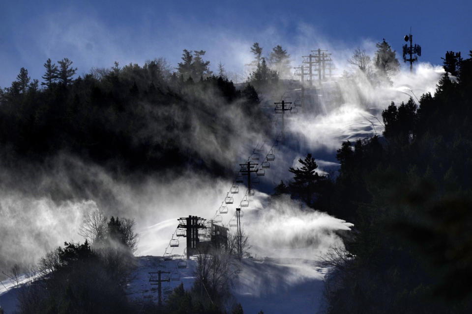 FILE - Snow is blown from snowmaking equipment near the summit of Pleasant Mountain ski resort, Dec. 21, 2023, in Bridgton, Maine. A new study says U.S. ski areas lost about $5 billion from 2000 to 2019 as a result of human-caused climate change. (AP Photo/Robert F. Bukaty, File)