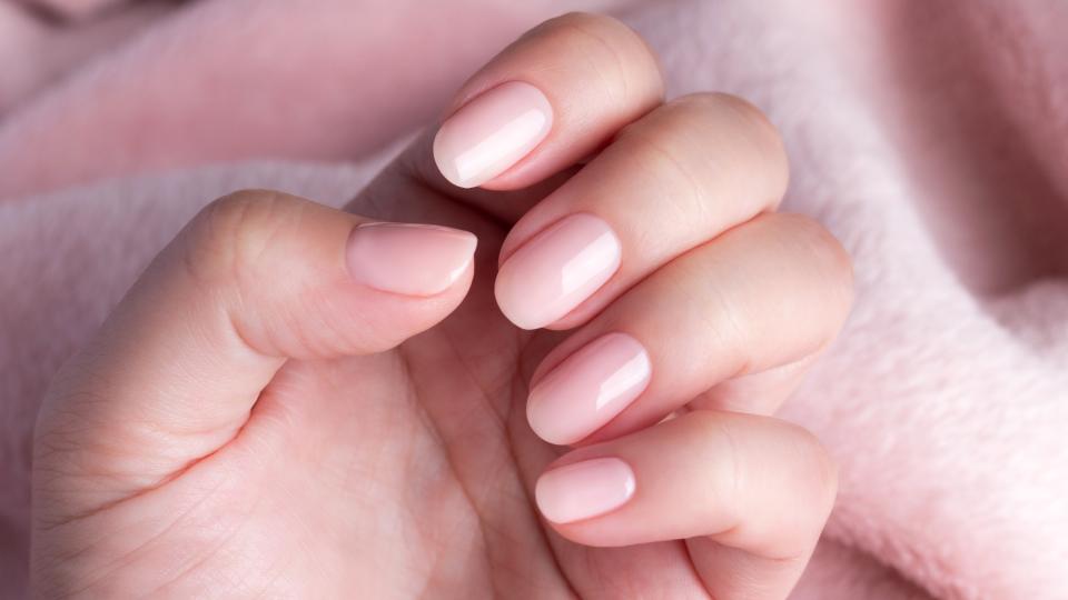 Hands with soft pink, glossy nail polish