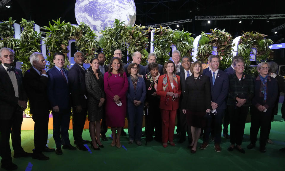 Nancy Pelosi, Speaker of the United States House of Representatives, front fifth right, and U.S. Rep. Alexandria Ocasio-Cortez, fifth left, and other US politicians pose for a group photo after arriving at the venue of the COP26 U.N. Climate Summit in Glasgow, Scotland, Tuesday, Nov. 9, 2021. The U.N. climate summit in Glasgow has entered it's second week as leaders from around the world, are gathering in Scotland's biggest city, to lay out their vision for addressing the common challenge of global warming. (AP Photo/Alberto Pezzali)
