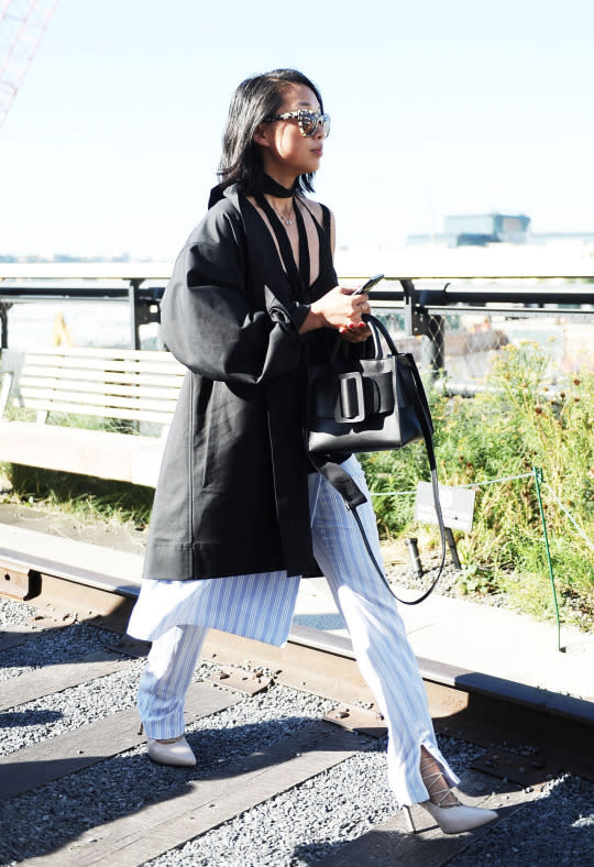 <p>Despite New York City’s hot, hot heat, Zhang was still all about the layers. She draped a black trench coat over blue pin-striped pants. </p>