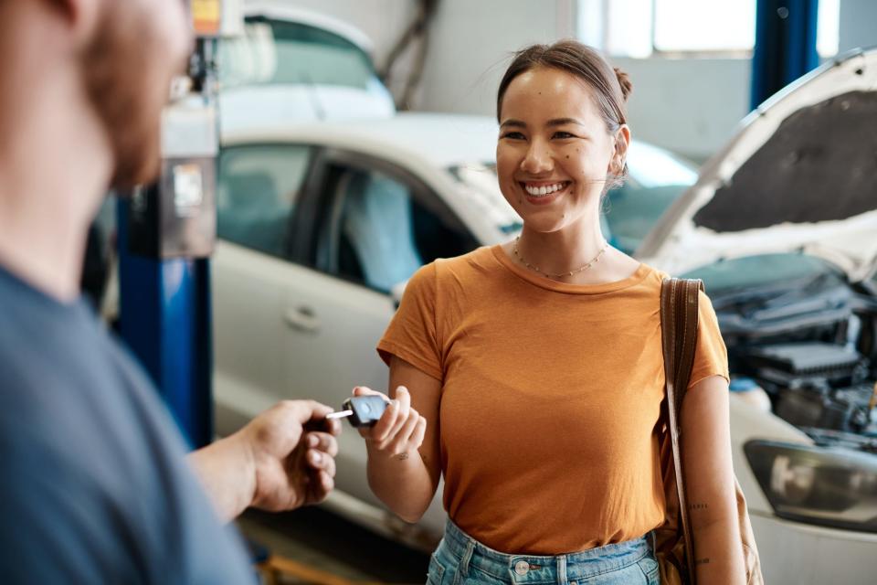 Woman gets keys to her new car from a dealership