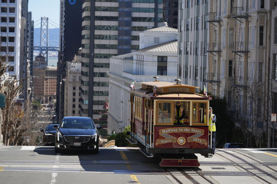 A cable car dedicated to Tony Bennett makes its way up California Street to Nob Hill in San Francisco, Thursday, March 14, 2024. Tony Bennett loved San Francisco and its cable cars and in return, the city has dedicated one of those cable cars to the famous crooner who died in July. Cable car 53, built in 1907, has several plaques and painted gold ribbons remembering Bennett. (AP Photo/Eric Risberg)