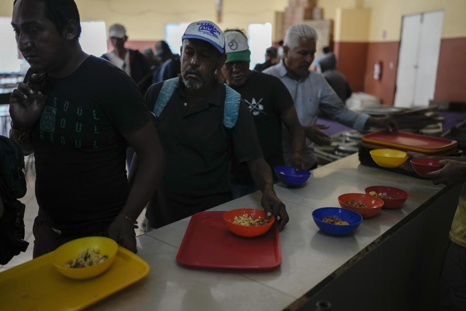Migrants get a hot meal at the Casa INDI Home and dining room for the poor, a shelter in Monterrey, Mexico, Thursday, April 11, 2024. Migrants are transforming this prosperous industrial city, but aren't part of Mexico's political conversation as the country gears up for its presidential vote on June 2. (AP Photo/Eduardo Verdugo)