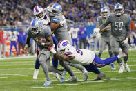Buffalo Bills defensive tackle DaQuan Jones (92) reaches in on Detroit Lions running back Jamaal Williams (30) during the second half of an NFL football game, Thursday, Nov. 24, 2022, in Detroit. (AP Photo/Paul Sancya)