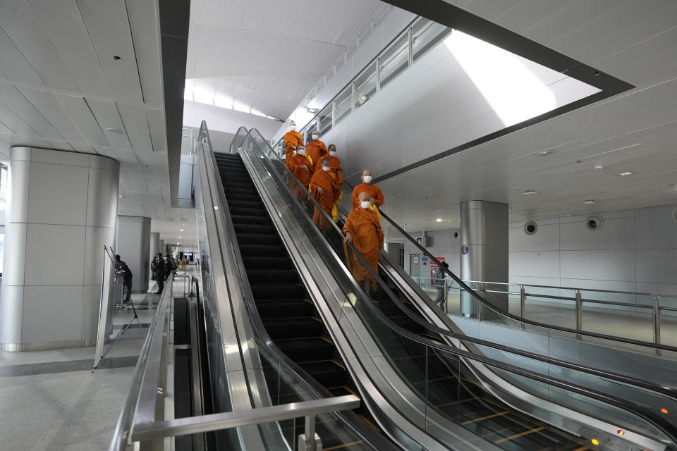 Buddhist monks ride on an escalator at Krung Thep Aphiwat Central Terminal in Bangkok, Thailand, Thursday, Jan. 19, 2023. Thailand ushered in a new age of train travel on Thursday when what’s said to be Southeast Asia’s biggest railway station officially began operations. (AP Photo/Sakchai Lalit)