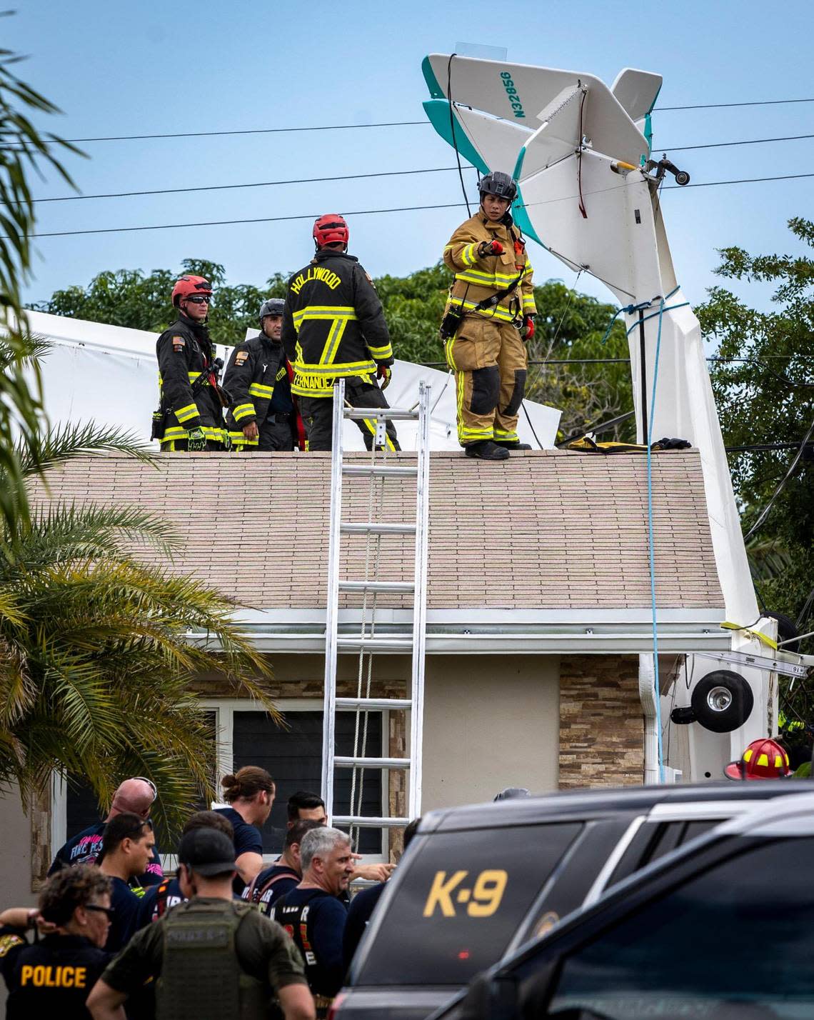 Fire rescue personnel on the roof of a house in Miramar, Florida, that a small plane crashed into on Oct. 17, 2022. Two people aboard the plane were killed in the crash. The house in the 200 block of Jamaica Drive is about half a mile from the southern edge of North Perry Airport.