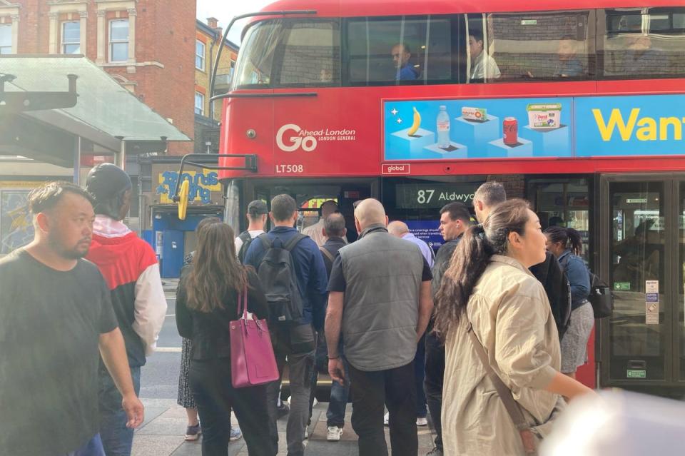 A group of passengers board a number 87 double-decker bus to Aldwych at a stop outside Clapham Junction station (PA)