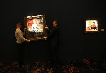 Staff hang 'La Parisienne De Montmartre' by Kees Van Dongwen at the exhibition sale of 'Modern Masters' during Sotheby's Beijing Art Week in Beijing, November 28, 2013. REUTERS/Kim Kyung-Hoon