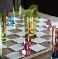 A chess set with translucent, colorful modern pieces on a board