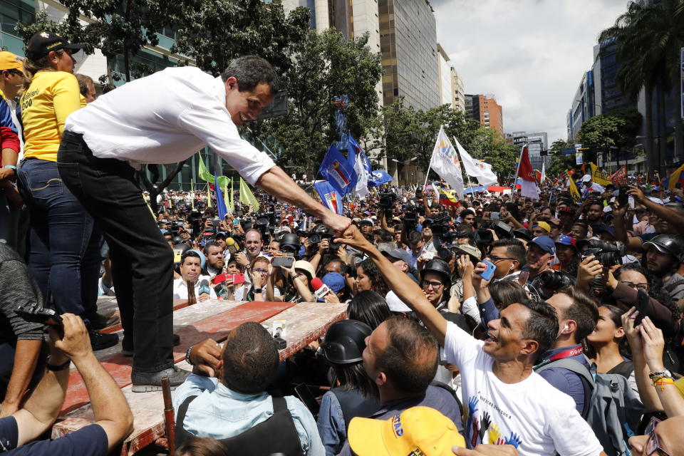 Opposition politician Juan Guaido fist bumps with a supporter during a rally, in Caracas, Venezuela, Saturday, Nov. 16, 2019. Guaido called nationwide demonstrations to re-ignite a campaign against President Nicolas Maduro launched in January that has lost steam in recent months. (AP Photo/Ariana Cubillos)