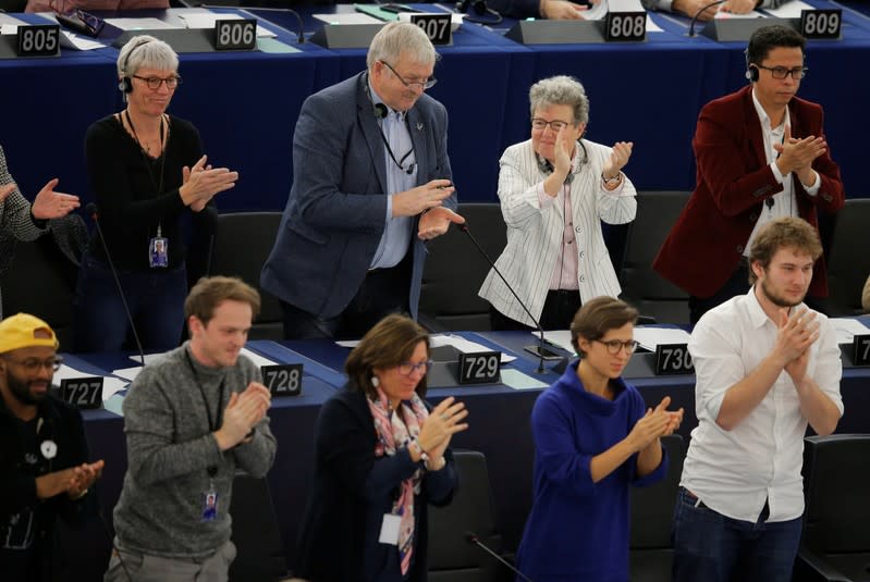 MEPs react after a vote during a voting session at the European Parliament in Strasbourg