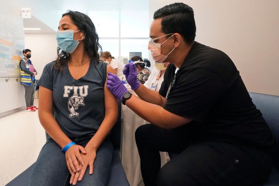 A pharmacy student giving another student a vaccine in Miami.