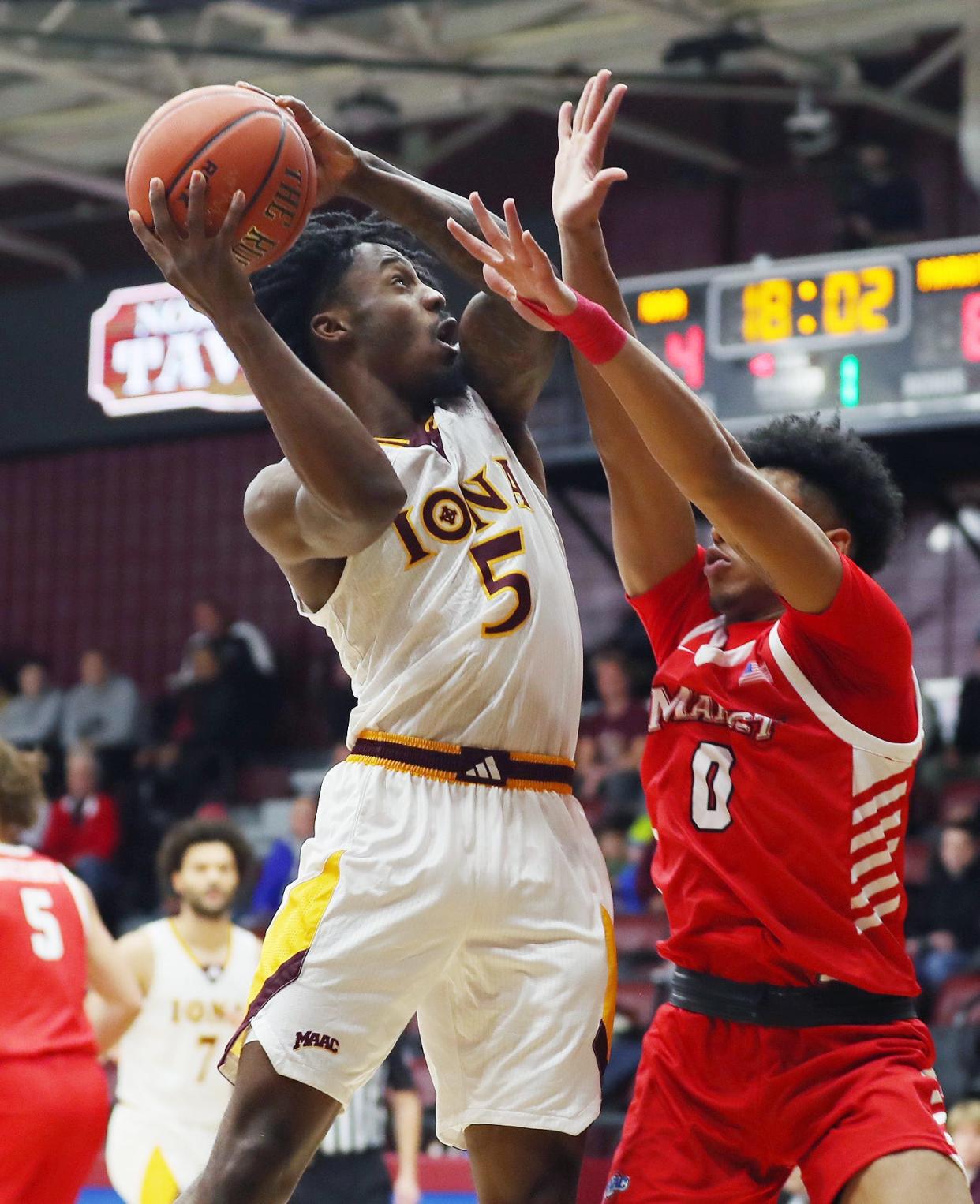 Iona's Joel Brown (5) puts up a shot in front of Marist's Jadin Collins (0) during NCAA basketball action at Hynes Center at Iona University in New Rochelle Nov. 29, 2023.