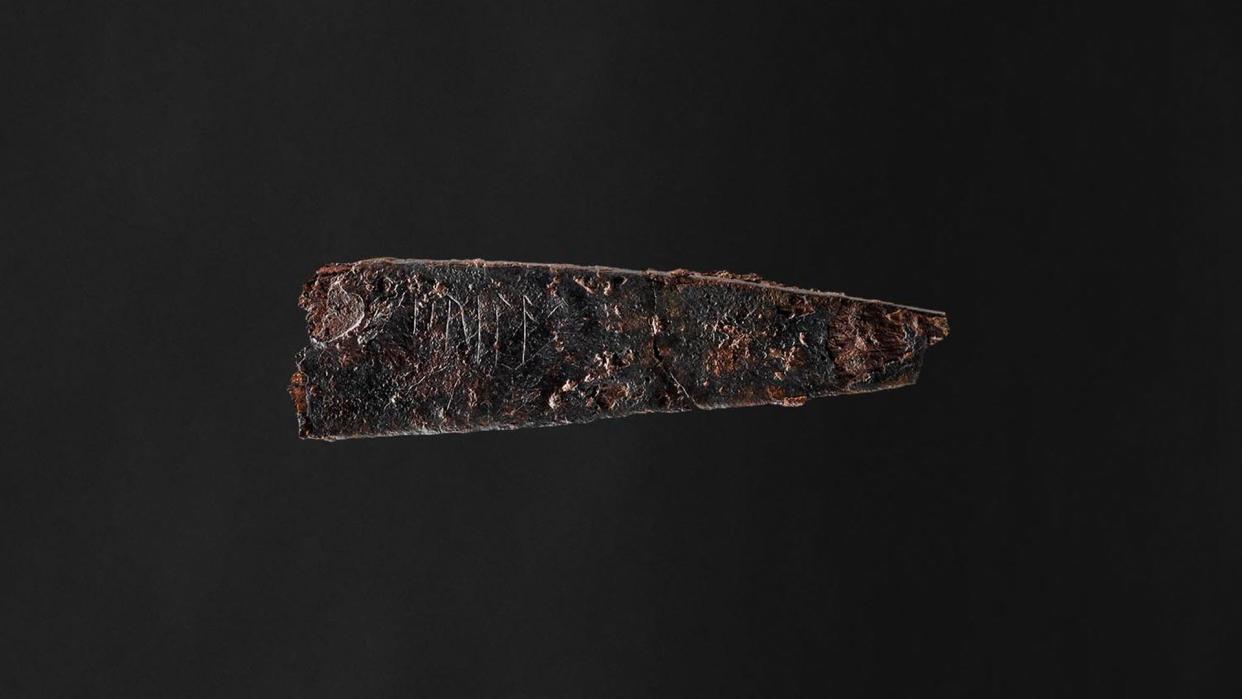  Side view of the blade of an 1,800-year-old iron knife with Danish runes that seem to spell out the word "hirila.". 