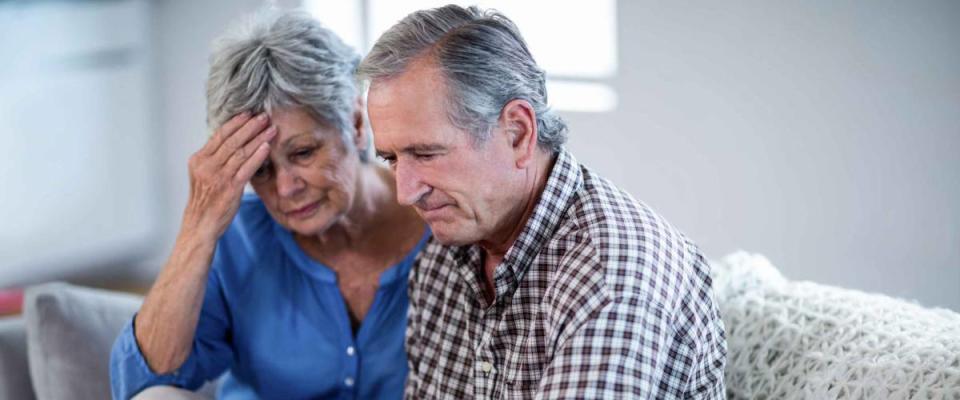 Worried senior couple checking the bills at home