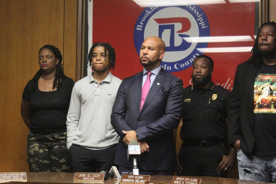 D'Monterrio Gibson, second from left, stands with his attorney Carlos Moore, center, at a press conference before jury selection in Lincoln County Circuit Court, Tuesday, Aug. 15, 2023, in Brookhaven, Miss. Gibson, a FedEx driver, was allegedly shot at by Gregory Case and his son Brandon Case.