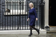 FILE - Britain's Prime Minister Liz Truss walks past Larry the Cat, Chief Mouser to the Cabinet Office as she leaves 10 Downing Street to attend parliament in London, on Sept. 23, 2022. The British government’s economic stimulus plan is designed to help people and businesses by cutting taxes and growing the economy. But it's had the opposite effect as the promise of huge unfunded tax cuts sparked turmoil in financial markets and sent the British pound tumbling to a record low against the U.S. dollar this week. (AP Photo/Kirsty Wigglesworth, File)