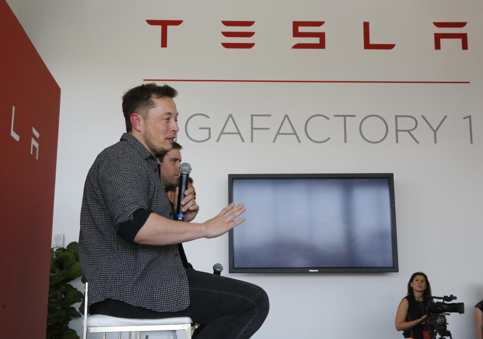 Elon Musk, CEO of Tesla Motors Inc., left, discusses the company's new Gigafactory Tuesday, July 26, 2016, in Sparks, Nev. It's Tesla Motors biggest bet yet: a massive, $5 billion factory in the Nevada desert that could nearly double the world's production of lithium-ion batteries by 2018. In the center is J.B. Straubel, Tesla's chief technical officer and at right is Yoshihiko Yamada, executive vice president of Panasonic. (AP Photo/Rich Pedroncelli)