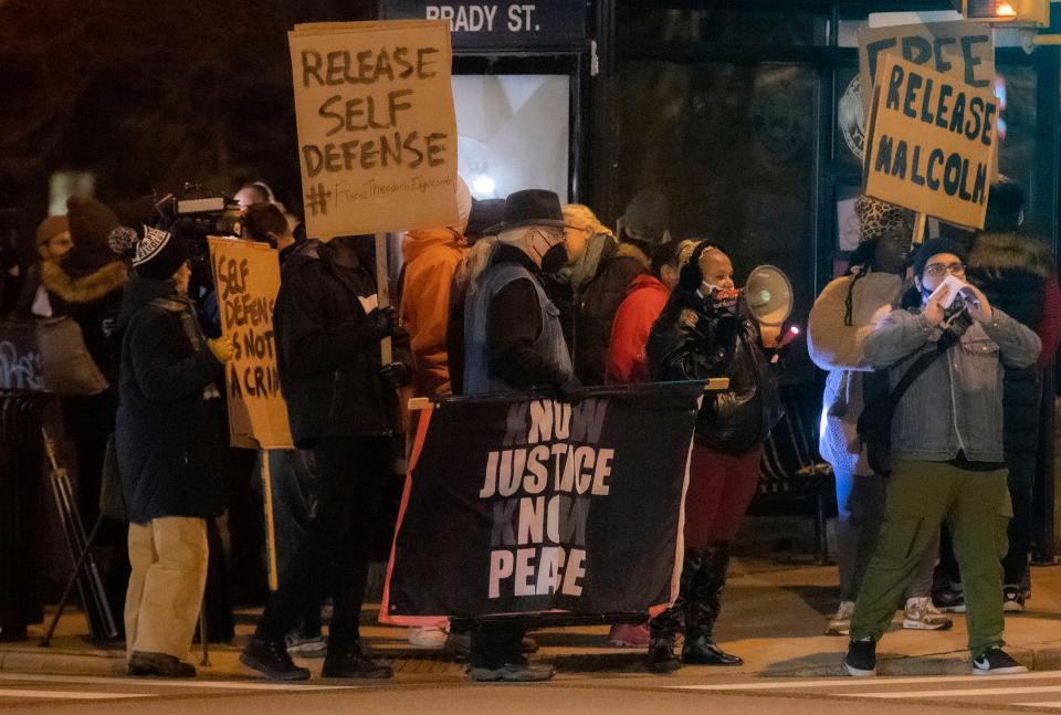 People hold makeshift signs at a picket in solidarity with Theodore Edgecomb, at the intersection of Brady and Holton, held by The Milwaukee Alliance Against Racist and Political Repression Dec. 17, 2021 in Milwaukee