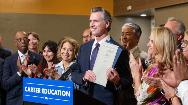 California Governor Gavin Newsom stands among a crowd