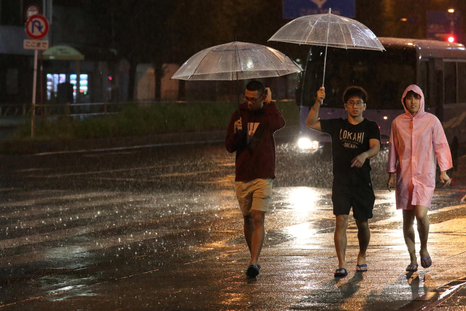 People walk on the street near Shinagawa Station as Typhoon Hagibis hit Tokyo, Japan, October 12, 2019. REUTERS/Kevin Coombs