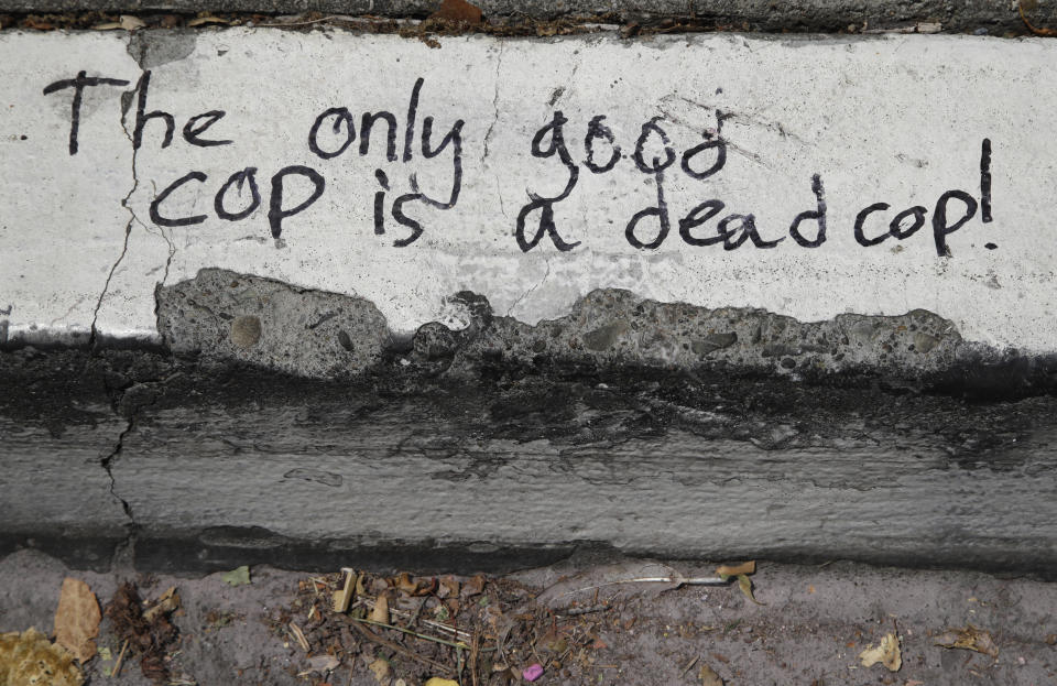 Graffiti is seen on the curb in front of Berkeley police headquarters seen on Wednesday, July 15, 2020, in Berkeley, Calif. The city of Berkeley, California, moved forward Wednesday with a proposal to eliminate police from conducting traffic stops and instead use unarmed civilian city workers as part of a broad overhaul of law enforcement. The City Council also set a goal of cutting the police budget by 50%. (AP Photo/Ben Margot)