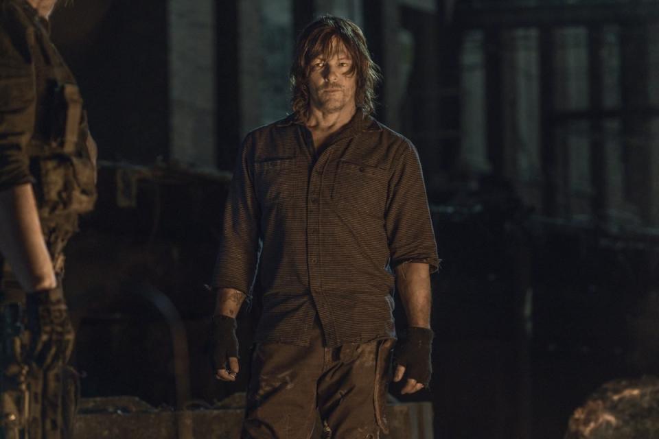 Daryl Dixon stands in front of a building at night saves leah best moments on the walking dead 