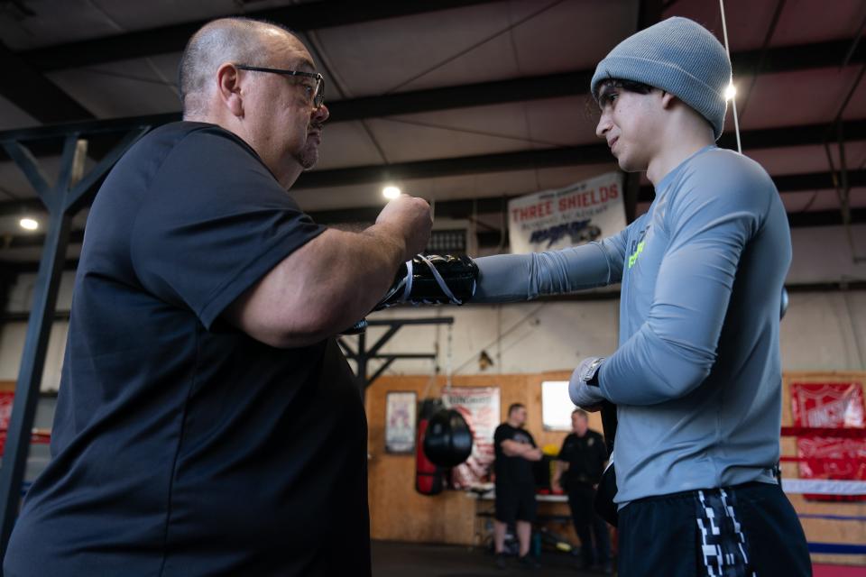 John Alcala helps Jalim Ramirez put on gloves before the 17-year-old starts sparring with a trainer at Three Shields Boxing Academy on Tuesday. Alcala, a Kansas representative and former Topeka City Council member, has played an integral part in the academy's success.