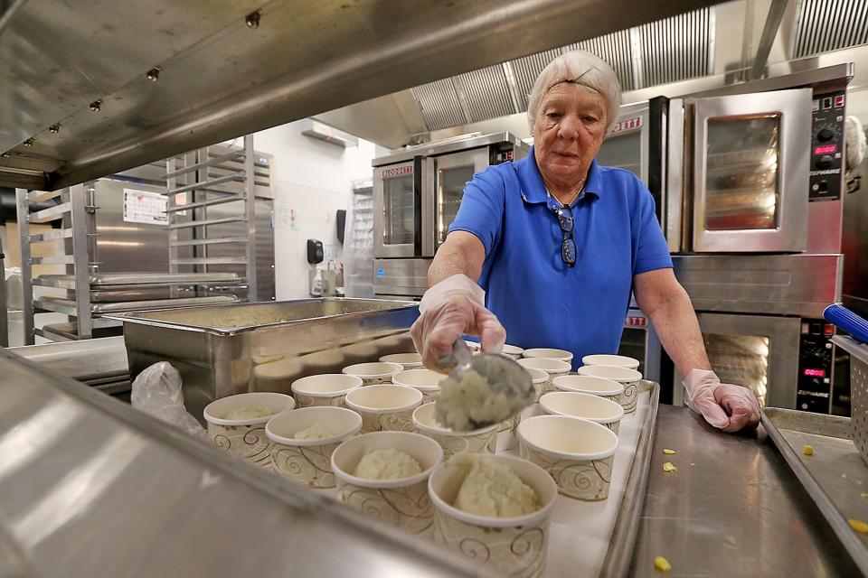 Ann Smith of East Middle School scoops out mashed potatoes while getting ready for the lunch period during a tour of East Middle School's cafeteria in Braintree on Thursday. About 3,500 students, or 66% of the district, are enjoying free lunches in the Braintree school system.