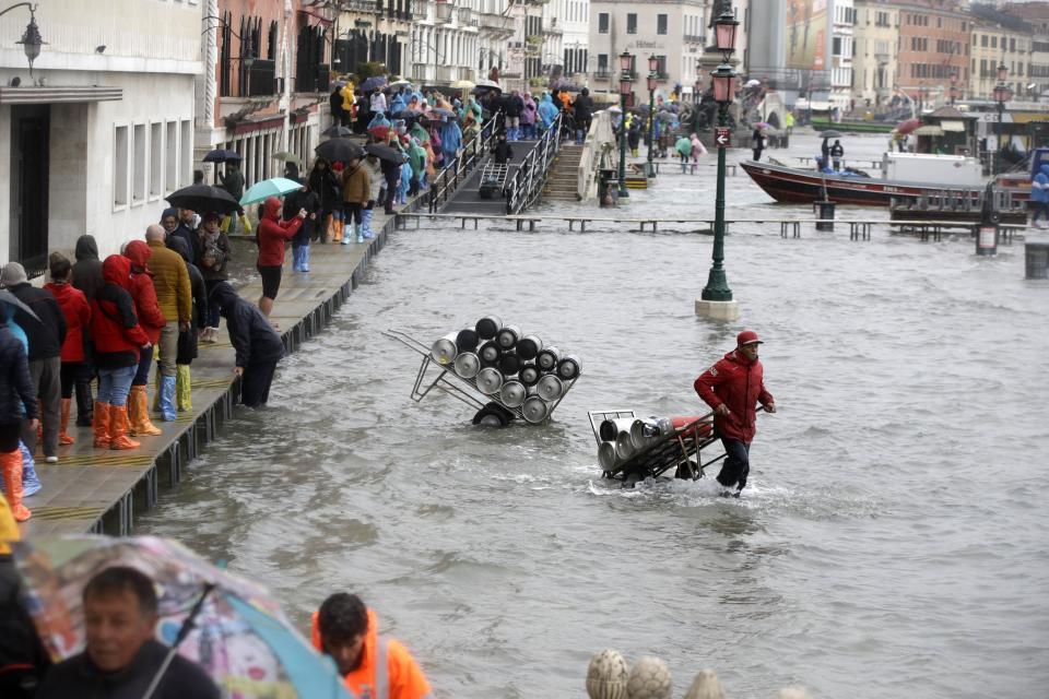 People walk on catwalks set up on the occasion of a high tide, in a flooded Venice, Italy, Tuesday, Nov. 12, 2019. (Photo: Luca Bruno/AP)