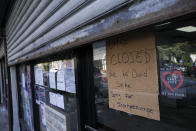 A storefront displays a closed sign as it remains shuttered due to a COVID-19 area infection rate increase, Thursday, Oct. 15, 2020, in the Far Rockaway neighborhood of the borough of Queens in New York. After shutdowns swept entire nations during the first surge of the coronavirus earlier this year, some countries and U.S. states are trying more targeted measures as cases rise again around the world. New York’s new round of shutdowns zeroes in on individual neighborhoods, closing schools and businesses in hot spots measuring just a few square miles. (AP Photo/John Minchillo)