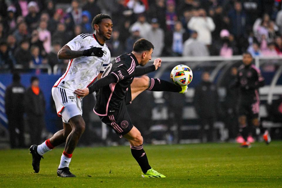 Inter Miami's Lionel Messi (10) and FC Dallas' Nkosi Tafari battle for control of the ball during the first half of an MLS preseason match at Cotton Bowl Stadium.