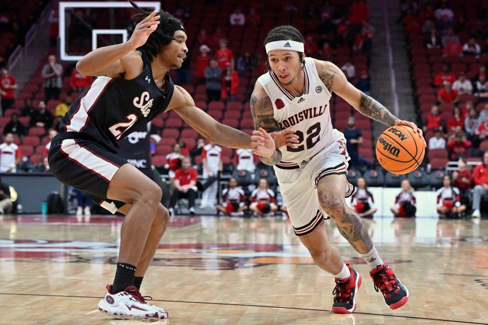 Nov 26, 2023; Louisville, Kentucky, USA; Louisville Cardinals guard Tre White (22) dribbles against New Mexico State Aggies forward Robert Carpenter (21) during overtime at KFC Yum! Center. Louisville defeated New Mexico State 90-84. Mandatory Credit: Jamie Rhodes-USA TODAY Sports