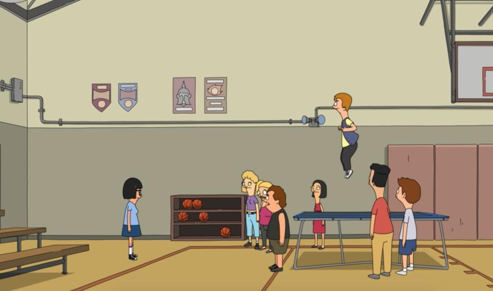 Tina standing in the gym in front of Jimmy Jr.s friends while he jumps on a trampoline in “Bob, Actually”