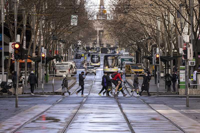 People are seen crossing Bourke Street Mall in Melbourne.