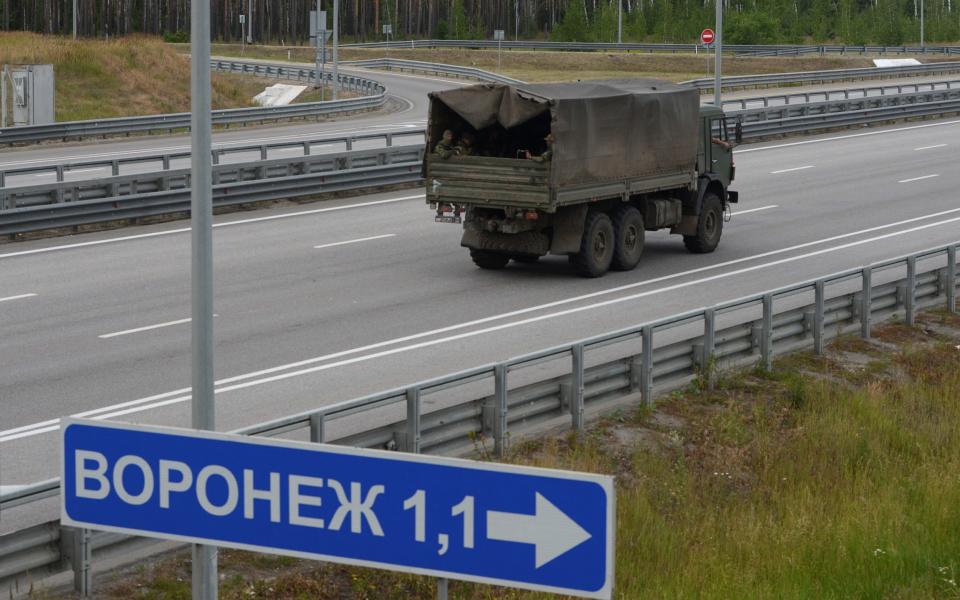 A truck transporting fighters of Wagner private mercenary group drives along M-4 highway, which links the capital Moscow with Russia's southern cities, near Voronezh, Russia, June 24, 2023. A sign reads: "Voronezh". REUTERS/Stringer