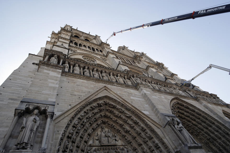 A crane works at Notre-Dame cathedral in Paris, Friday, April 19, 2019. Rebuilding Notre Dame, the 800-year-old Paris cathedral devastated by fire this week, will cost billions of dollars as architects, historians and artisans work to preserve the medieval landmark. (Philippe Wojazer/Pool via AP)